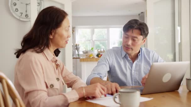 一对成熟的亚洲夫妇坐在桌旁 用笔记本电脑整理家庭账单和财务 动作缓慢 — 图库视频影像