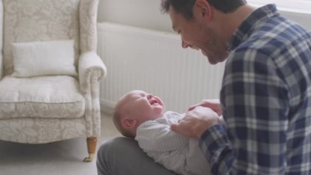 Kærlig Far Krammer Smilende Lille Søn Liggende Skødet Hjemme Sammen – Stock-video