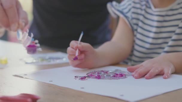 父亲和年幼的女儿在家里玩的很开心 他们坐在桌旁 一起粉刷装饰 动作缓慢 — 图库视频影像