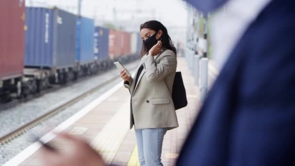 Los Viajeros Negocios Plataforma Ferroviaria Con Teléfonos Móviles Con Máscaras — Vídeo de stock
