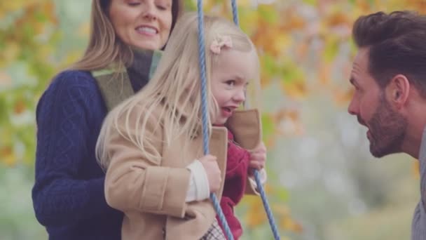 Padres Empujando Hija Divirtiéndose Columpio Cuerda Jardín Otoño — Vídeos de Stock