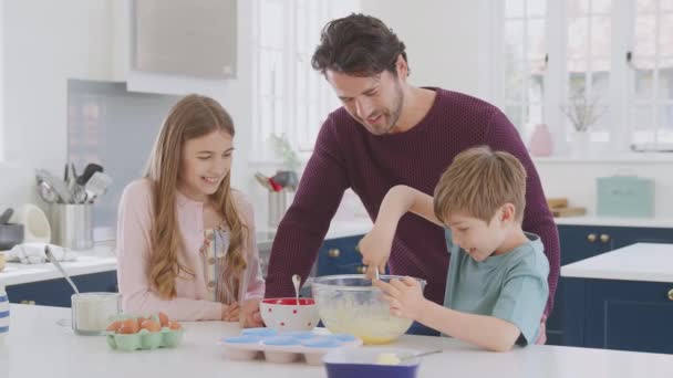 Padre Con Dos Hijos Cocina Casa Divirtiéndose Horneando Pasteles Juntos — Vídeos de Stock