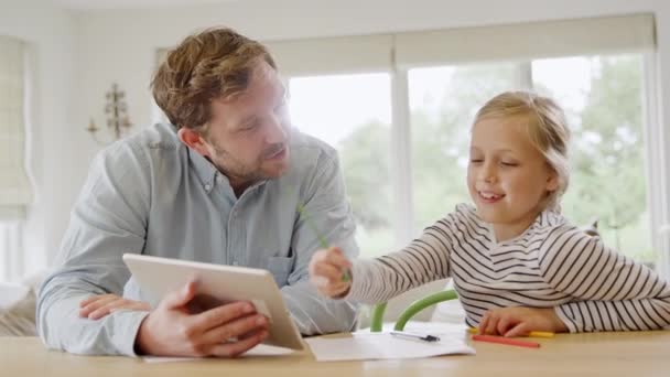 在健康大流行期间 父亲帮助女儿坐在餐桌旁 用数码餐具在家上学 — 图库视频影像