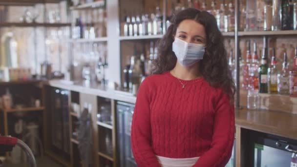 健康中に顔マスクを着用する女性バーワーカーの肖像 パンデミックカウンターの後ろに立つ — ストック動画