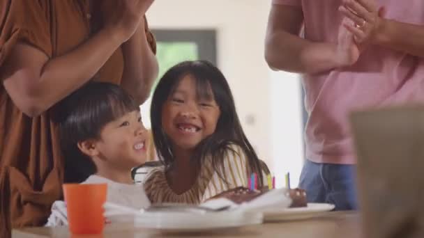 アジアの家族は息子の誕生日を自宅で祝うキャンドルカバーケーキで彼を驚かせます — ストック動画