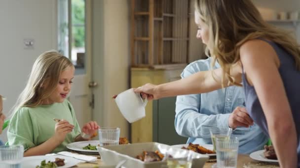 Rodzice Służąc Jedzenie Jako Rodzina Siedzieć Przy Stole Domu Cieszyć — Wideo stockowe