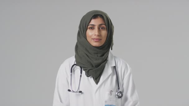 Portrait Serious Female Doctor Headscarf Wearing White Coat Plain Background — Stok Video