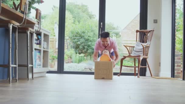 亚洲父亲和儿子推儿子绕着厨房地板在家里的灌篮模型车 — 图库视频影像