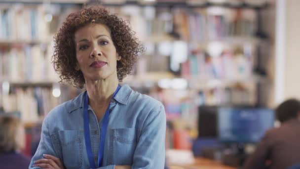 Kütüphanede Diğer Öğrencilerin Ağır Çekimde Okuduğu Ciddi Yetişkin Bayan Öğretmen — Stok video