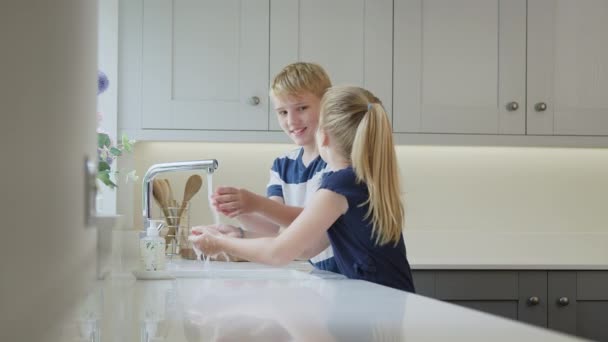 男孩和女孩在厨房的水池里洗手 以防止在大流行病期间病毒传播 慢动作射击 — 图库视频影像