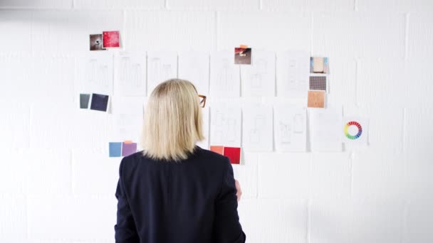 Widok Tyłu Dojrzałej Projektantki Mody Umieszczającej Kolorowe Próbki Ścianie Studia — Wideo stockowe