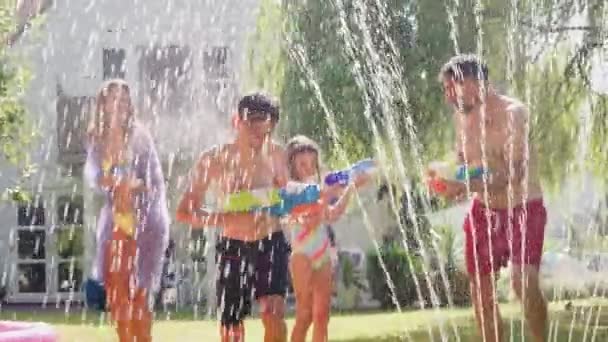 Gezin Zwemkleding Met Waterpistolen Zomertuin Geschoten Slow Motion — Stockvideo