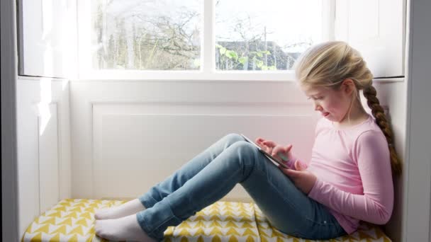 Вид Сбоку Маленькую Девочку Сидящую Дома Подоконнике Играющую Цифровом Планшете — стоковое видео