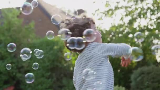 Junge Hat Spaß Bei Gartenjagd Und Blasenplatzen Schuss Zeitlupe — Stockvideo