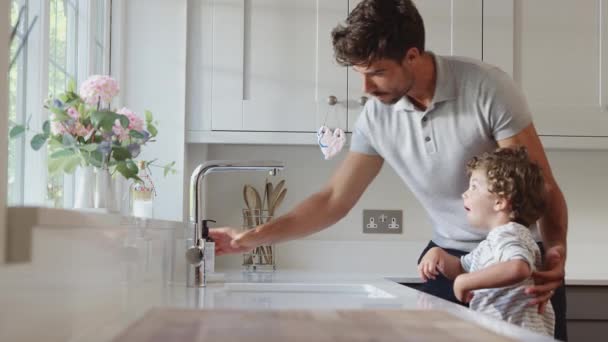 Padre Ayudando Hijo Pequeño Lavarse Las Manos Fregadero Cocina Durante — Vídeo de stock