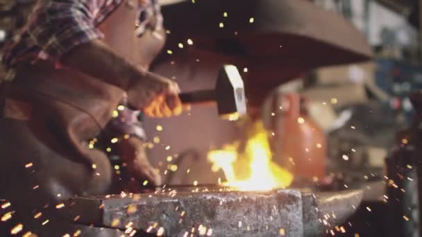 Zbliżenie Męskiego Kowala Młotkującego Metalową Robotę Kowadle Iskrami Płonącą Kuźnią — Wideo stockowe