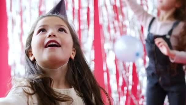 Grupa Dzieci Świętujących Przyjęciu Urodzinowym Papierowych Kapeluszach Bawiących Się Balonami — Wideo stockowe