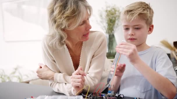 Nieto Con Abuela Ensamblando Componentes Electrónicos Para Construir Robots Juntos — Vídeo de stock