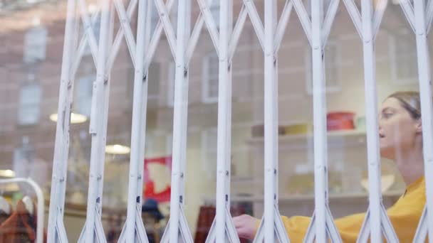 Woman Running Small Business Pushing Back Security Grill Window Opening — Stockvideo