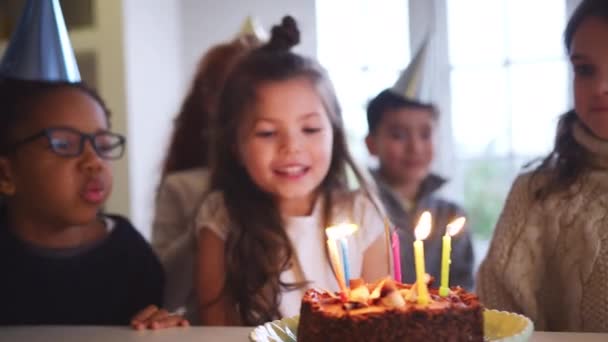 若い女の子お祝いの誕生日パーティーや友人のグループとともに自宅でパーティーケーキの上にろうそくを吹いて スローモーションで撮影 — ストック動画