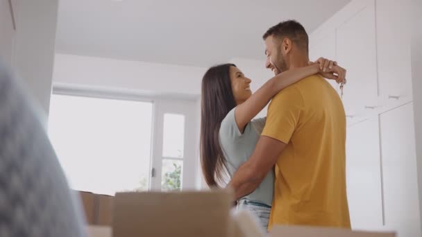 Pár Klíči Novému Domovu Obklopený Krabicemi Objímající Pohybující Den Záběr — Stock video