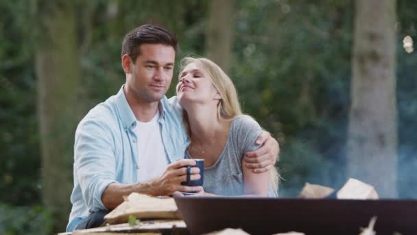 田舎のロマンチックなカップルのキャンプは 熱い飲み物で火のボウルにたき火で座って スローモーションで撮影 — ストック動画