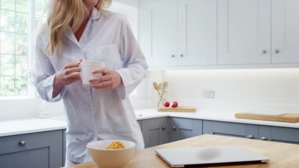 Жінка Піжамах Кухні Вдома Використовує Ноутбук Під Час Сніданку Пиття — стокове відео