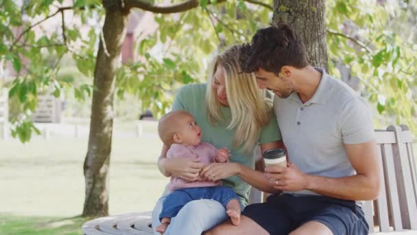 Famiglia Amorevole Con Bambina Seduta Sul Sedile Sotto Albero Nel — Video Stock