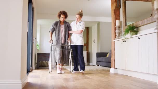 Reife Frau Morgenmantel Mit Gehgestell Die Von Einer Krankenschwester Unterstützt — Stockvideo