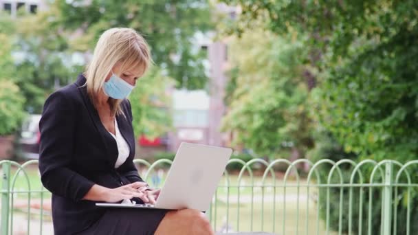 Volwassen Zakenvrouw Dragen Gezicht Masker Zitten Bank Stadspark Werken Laptop — Stockvideo