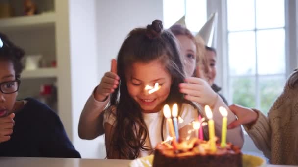 パーティーや友人のグループと一緒に家で誕生日を祝う若い女の子には キラキラとキャンドルで飾られたケーキを与えられています スローモーションで撮影 — ストック動画