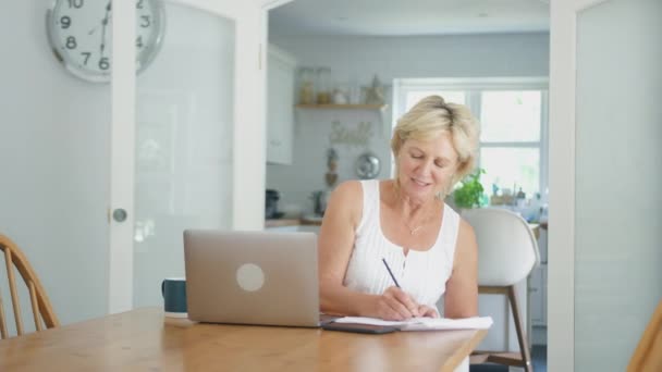 Pensionerad Äldre Kvinna Hemma Köket Med Bärbar Dator För Att — Stockvideo