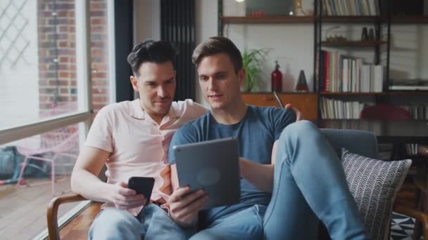 Couple Masculin Même Sexe Assis Sur Canapé Utilisant Une Tablette — Video