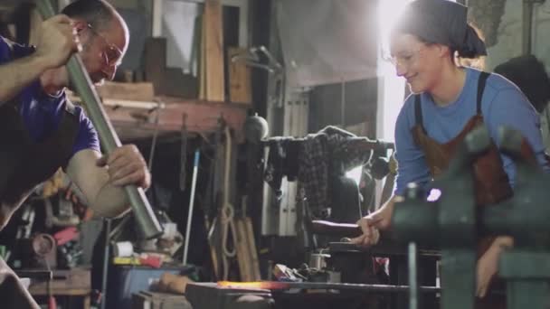 铁匠和铁匠一起在铁锹上锤击着炽热的红色金属制品 动作缓慢 — 图库视频影像