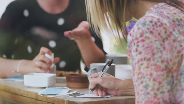 Two Female Friends Coffee Shop Use Hand Sanitizer Fill Test — Vídeo de Stock