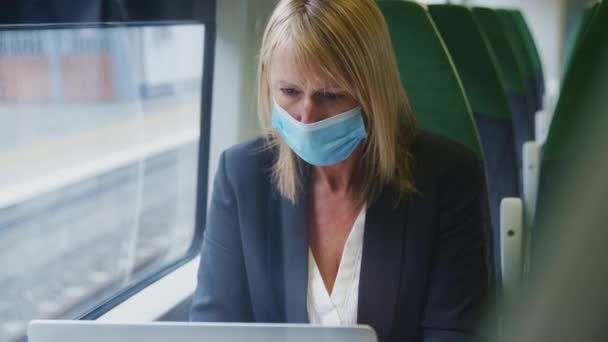 Mature Businesswoman Wearing Face Mask Train Working Laptop Shot Slow — Stock Video