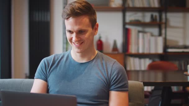 Jeune Homme Souriant Assis Sur Canapé Travailler Maison Sur Ordinateur — Video