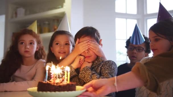 家でパーティーや友人のグループと一緒に誕生日を祝う若い男の子には キラキラとキャンドルで飾られたケーキを与えられています スローモーションで撮影 — ストック動画