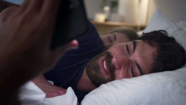 男人在晚上躺在床上用手机发短信 动作缓慢 — 图库视频影像