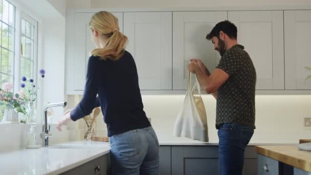 Ζευγάρι Πλύσιμο Των Χεριών Και Ξεπακετάρισμα Ψώνια Στην Κουζίνα Στο — Αρχείο Βίντεο