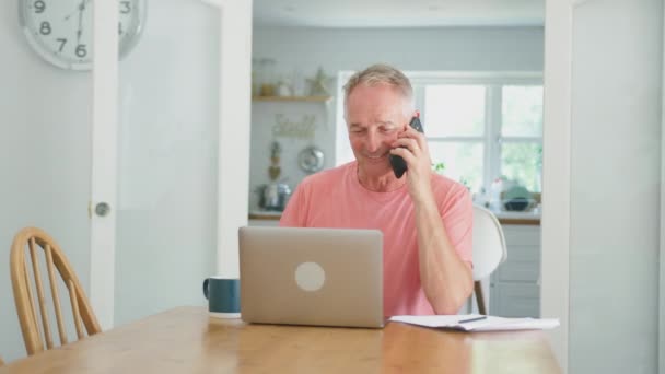 Pensionerad Äldre Man Telefon Hemma Köket Med Bärbar Dator Firar — Stockvideo