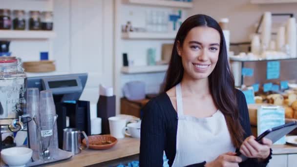 커피숍을 운영하고 디지탈 태블릿을 가지고 동작으로 거꾸로 미소짓는 여자의 — 비디오