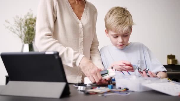 Barnebarn Med Bestemor Som Setter Sammen Elektroniske Komponenter Bygge Robot – stockvideo