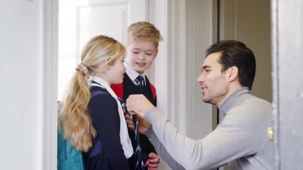 父チェック制服と矯正ネクタイの息子と娘として彼らは学校のために家を出る スローモーションで撮影 — ストック動画