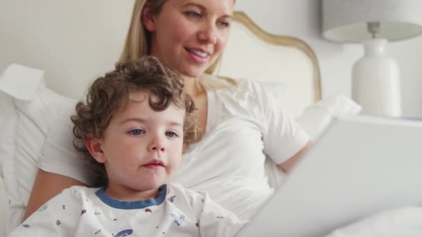 Madre Mirando Libro Fotos Con Hijo Usando Pijamas Antes Irse — Vídeo de stock