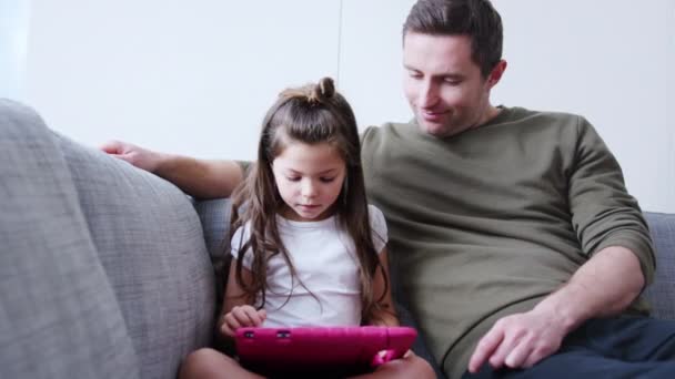Father Daughter Sitting Sofa Home Playing Computer Game Together Digital — 图库视频影像