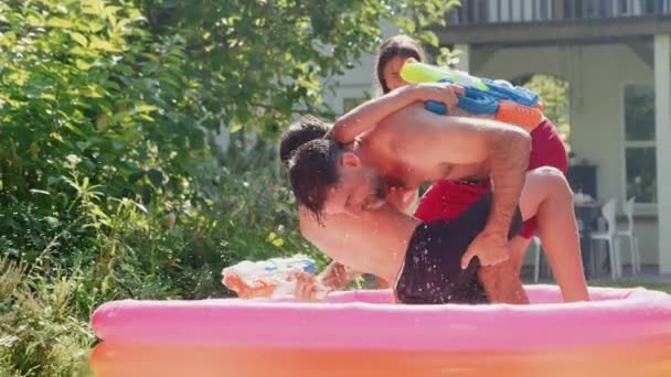 Vader Kinderen Zwemkleding Die Met Waterpistolen Vechten Zomertuin Geschoten Slow — Stockvideo