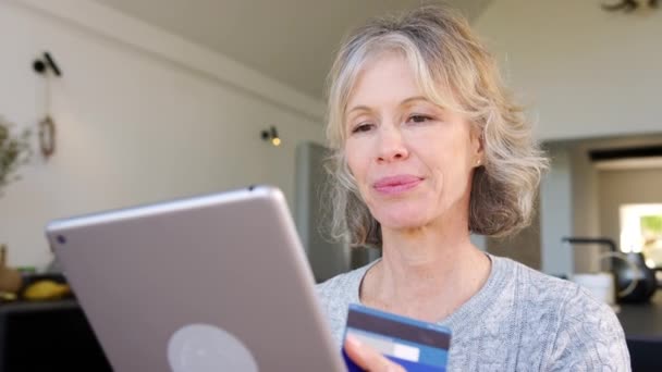 自宅で高齢者のカップルは デジタルタブレットやクレジットカードを使用してオンラインで製品やサービスを購入 スローモーションで撮影 — ストック動画