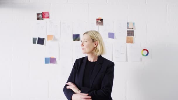 Olgun Kadın Moda Tasarımcısının Portresi Stüdyoda Duvarın Önünde Duruyor Çizimler — Stok video