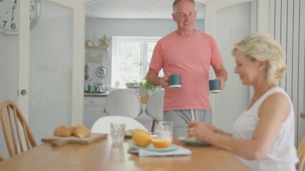 Συνταξιούχοι Ηλικιωμένοι Ζευγάρι Στο Σπίτι Γύρω Από Τραπέζι Στην Κουζίνα — Αρχείο Βίντεο